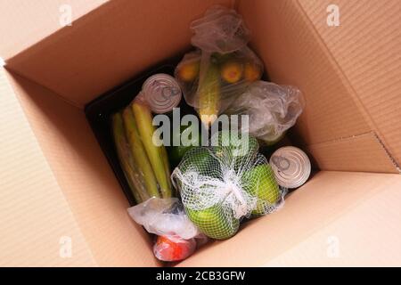 Lieferung von Waren an die Tür. Kommissionierer Verpackung Lebensmittel in einem Karton-Boxen. Stockfoto