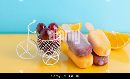Ein Fruchteis und ein kleines Fahrrad mit Kirsche. Sommerzeit Stockfoto