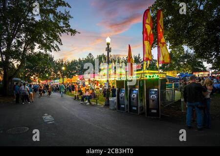 Touristen und Einheimische genießen das alljährliche Pig Out in the Park im Riverfront Park, Spokane Washington, während sie an Imbissständen und Verkäufern essen, wenn die Nacht hereinbricht Stockfoto