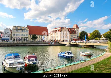 Das farbenfrohe Ostseedorf Warnemunde Rostock, Deutschland, mit Booten im Alten Strom Kanal und Touristen genießen einen Sommertag. Stockfoto