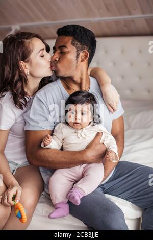 Mann hält ein Baby und küsst seine Frau, Liebe, Nähe, Emotion, Gefühl . Nahaufnahme Foto Stockfoto