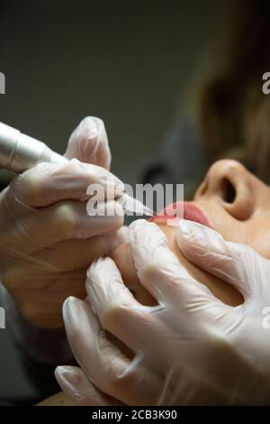 Junge Frau unterziehen Verfahren der permanenten Lippen Make-up in Tattoo-Salon, Nahaufnahme Stockfoto