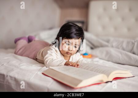 Clever Baby Mädchen starren auf Buch, Nahaufnahme Foto, Wissen ist Macht, Bildung für kleine Kinder Stockfoto