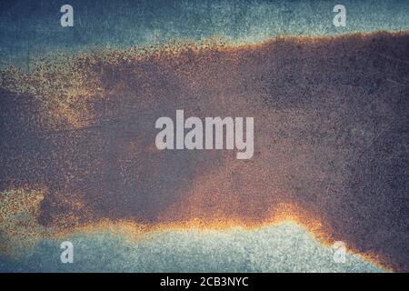 Abstrakter Hintergrund aus verrosteten Metall mit blauen, grünen und orangen Tönen. Texturierter Hintergrund für Überlagerung oder das Hinzufügen von Text. Stockfoto