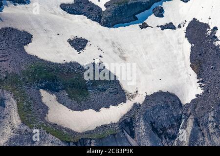 Schneefeld und Talushänge über dem Nisqually Glacier im Juli im Mount Rainier National Park, Washington State, USA Stockfoto