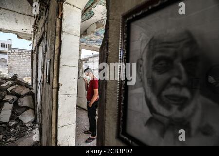 Idlib, Syrien. August 2020. Ein Besucher besucht eine Ausstellung des syrischen Künstlers Rami Abd al-Haq, die am 10. August 2020 in einem der beschädigten Häuser in Idlib, Syrien, gezeigt wurde. Die Zeichnungen zeigen Figuren und Figuren, die während des syrischen Bürgerkriegs entstanden sind. (Foto von Azalden Idlib/INA Photo Agency/Sipa USA) Quelle: SIPA USA/Alamy Live News Stockfoto