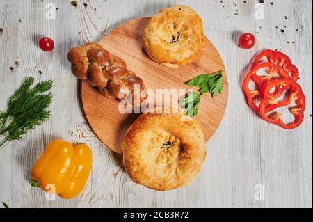 Draufsicht auf Laibe von Pita Brot gebunden zusammen mit und String mit Weizenohren auf einem bemehlten schwarzen Hintergrund verziert. Stockfoto