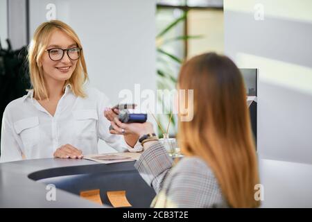 Attraktive Erwachsene schöne Frau mit kurzen blonden Haaren kam als Kunde in Beauty-Salon Schönheitsverfahren zu bekommen, Make-up der Veränderung Frisur zu tun. Stockfoto