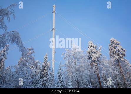 Komplett schneebedeckten Guy-Wire unterstützt Telekommunikation Mast im Wald im Winter, Finnland Stockfoto