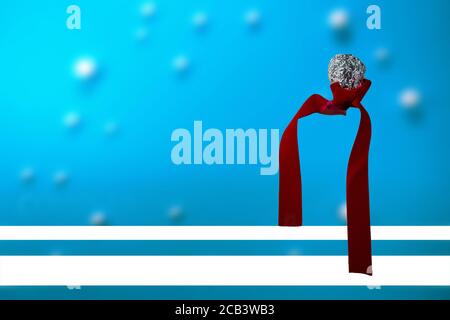 Nahaufnahme einer zerknitterten Kugel aus Aluminiumfolie mit einem Rotes Band Stockfoto