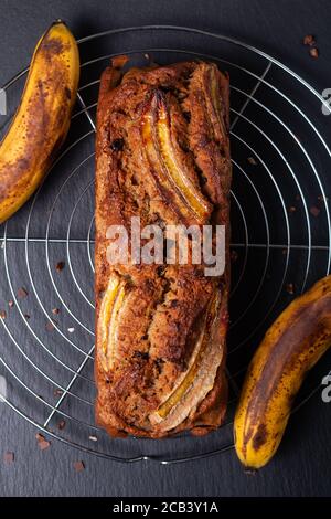 Essen Dessert-Konzept frisch gebackene Bio-rustikalen Bananenbrot auf Schwarzes Schiefersteinbrett Stockfoto