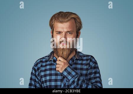 Foto von bärtig stilvolle gut aussehend zuversichtlich perfekte Frisur Mann hält zeigt Bart. Hipster Männchen mit Bart in blau kariert kariert Hemd isoliert o Stockfoto