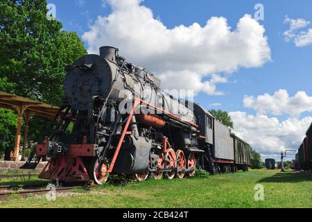 HAAPSALU, ESTLAND - 30. Juli 2020: Eisenbahnmuseum in der Stadt Haapsalu. Im Vordergrund die alte Lokomotive und der Bahnhof. Szene Stockfoto