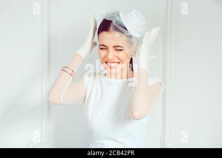 Schöne junge Frau im eleganten Brautoutfit hält die Hände in der Nähe Schläfen in Stress während Stirnrunzeln auf weißem Hintergrund Stockfoto
