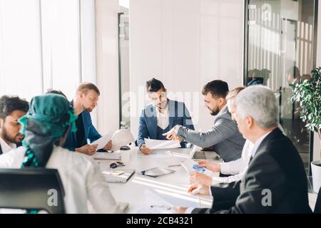 Junge intelligente kaukasischen Unternehmer sein Projekt Ideen teilen mit Executive Business Team Plan erstellen, analysieren den Markt und studieren Grafiken Cha Stockfoto