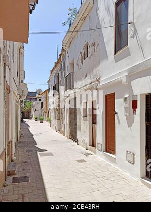 Charmante schmale, weiß getünchte Straße während des heißen Sommertages der touristischen spanischen Stadt Denia. Valencianische Gemeinschaft, Provinz Alicante, Stockfoto