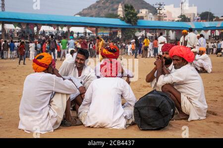 11. Dezember 2019 Pushkar Rajesthan, Indien Mann sitzt auf dem Boden während Pushkar Messe in pushkar Messe Boden. Stockfoto