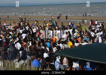 Hunderte steigen am Strand von Camber Sands ab, um den Jahrestag der jamaikanischen Unabhängigkeit zu feiern, der 1962 stattfand. Ängste vor einem zweiten Spike von Covid 19 schienen im Hinterkopf der Menschen zu sein, da soziale Distanzierung manchmal schwierig wurde. Polizeipräsenz Beobachten Sie die Menschenmengen in sicherer Entfernung und erinnern Sie die Menschen daran, möglichst einen sicheren Abstand einzuhalten. Die Veranstalter ermutigten den ganzen Tag über soziale Distanzierungen und baten alle, so sicher und ordentlich wie möglich zu sein. Außerdem spendete sie £750 für die lokale Müllernte, um bei der Müllernte zu helfen Stockfoto