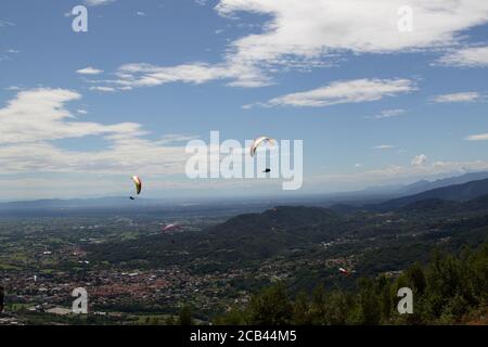 Belice, Italien - Sommer 2020: Italienische Paragliding-Meisterschaft, Teilnehmer fliegen auf der Val Padana Luftlandschaft Stockfoto