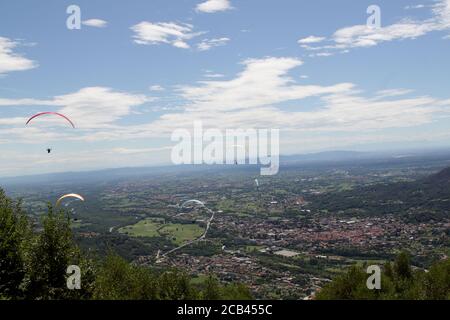 Belice, Italien - Sommer 2020: Italienische Paragliding-Meisterschaft, Teilnehmer fliegen auf der Val Padana Luftlandschaft Stockfoto