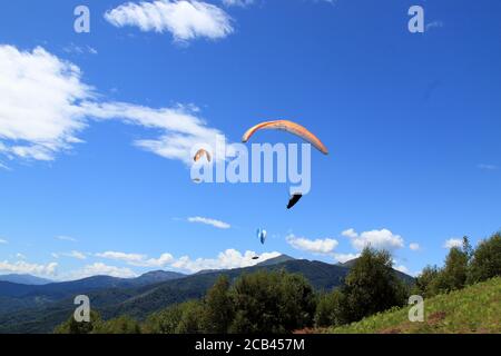 Belice, Italien - Sommer 2020: Italienische Paragliding-Meisterschaft, Teilnehmer fliegen auf der Val Padana Luftlandschaft Stockfoto