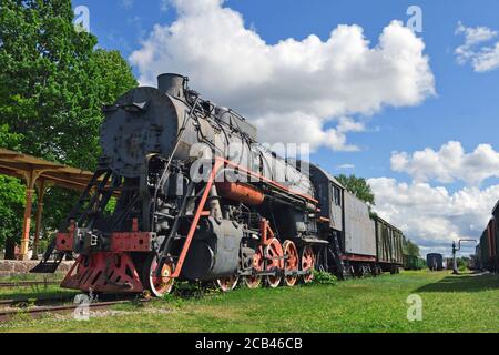 HAAPSALU, ESTLAND - 30. Juli 2020: Eisenbahnmuseum in der Stadt Haapsalu. Im Vordergrund die alte Lokomotive und der Bahnhof. Szene Stockfoto