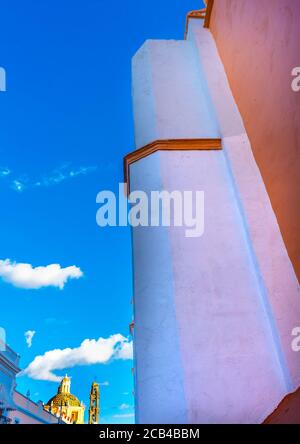 Orange Fassade Santa Clara de Asis Kirche Historisches Puebla Mexiko. Sam Cristobal Kirche im Hintergrund. Stockfoto