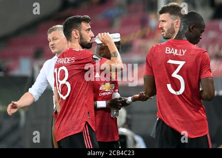 Köln, Deutschland. August 2020. Fußball: Europa League, Manchester United - FC Kopenhagen, Achtelfinale, Viertelfinale im Rhein-Energie-Stadion. Bruno Fernandes (2. V.l.), Fred (Undercover), David de Gea und Eric Bailly aus Manchester sprechen während einer Trinkpause miteinander, während Trainer Ole Gunnar Solskjaer (links) Anweisungen gibt. Quelle: Federico Gambarini/dpa/Alamy Live News Stockfoto