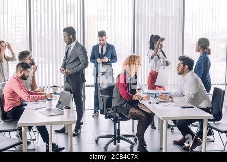 Young Business Team mit einer Unterbrechung während der Teilnahme in einem Brainstorming Sitzen oder Gehen herum und Austausch neuer Ideen mit Kollegen. Stockfoto