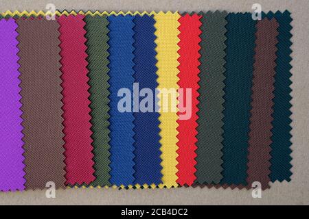 Muster von Stoff in verschiedenen Farben. Dickes Gewebe zum Nähen von Taschen und Rucksäcken. Blauer, gelber, grüner und brauner Stoff. Stockfoto