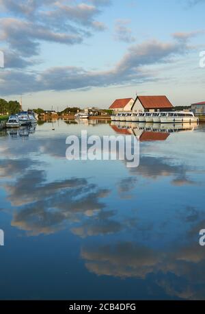 Bootsschuppen und Bootsverleih bei Potter Heigham spiegelt sich im Fluss Thurne, Norfolk frühen Sommermorgen Stockfoto