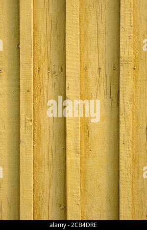 Nahaufnahme mit gelbem Holzhintergrund. Holzlatten sind gelb. Relieffläche von bemalten Holzbrettern. Stockfoto