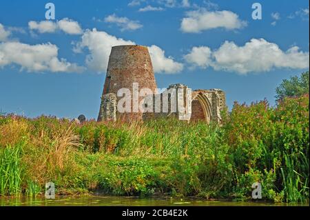 Überreste der Abtei St. Benet und Windmühle am Ufer des Flusses Bure, Norfolk Broads, Norfolk. Stockfoto