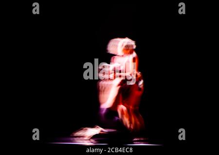Verschwommene Bewegung von Tänzern in zeitgenössischer Tanzperformance mit Dunkelheit Hintergrund Stockfoto