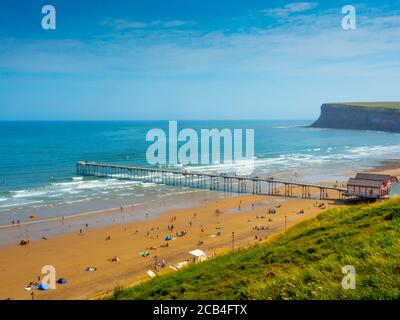 Saltburn am Meer Blick von der Klippe über dem pier nach Süden zu Huntcliff Sommerurlauber am Strand richtig Sozial distanziert Stockfoto