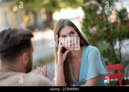 Trauriges Paar, das im Open-Air-Café sitzt und Missverständnisse hat Stockfoto