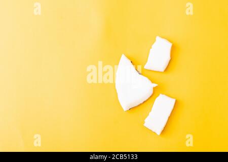 Happy Coconuts Tageskonzept, frische Kokosnuss Gruppe Stücke Scheiben, Studio Shot isoliert auf gelbem Hintergrund Stockfoto