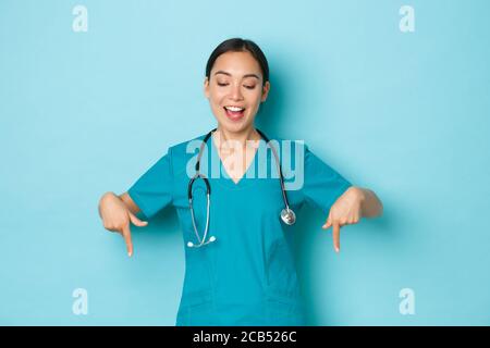 Covid-19, Social Distancing and Coronavirus pandemic concept. Fröhlich lächelnd asiatische Ärztin, Krankenschwester im Labor oder in der Klinik tragen Scrubs zeigen Stockfoto