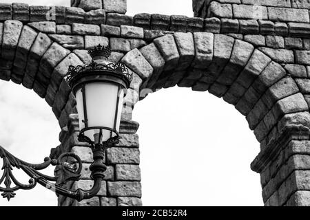 Low-Angle-Graustufenaufnahme einer Straßenlampe in der Nähe eines Alte Steinbrücke Stockfoto