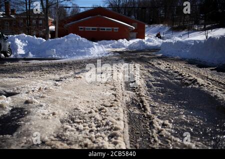 Die Slush Straße und die Schneebänke beiseite an sonnigen hellen Tag Stockfoto