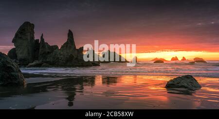 Feuriger Sonnenuntergang über der Castle Rock Formation am Bandon Beach in Oregon. Stockfoto