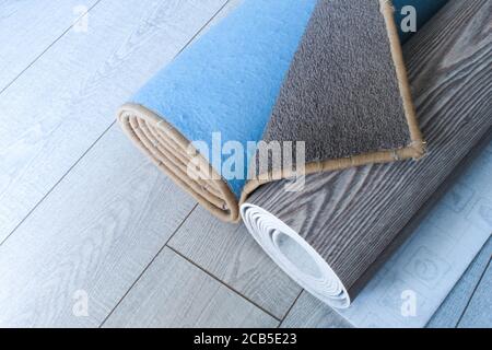 Teppich und Linoleum sind aufgerollt und liegen auf dem Laminatboden Stockfoto