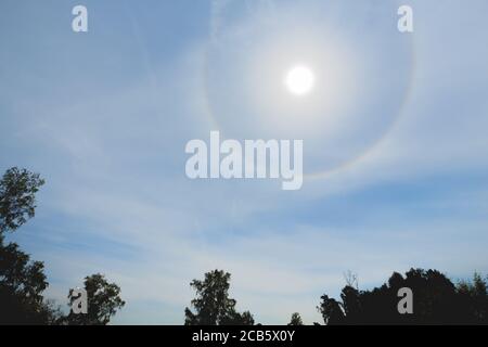 Atmosphärischer optischer Effekt umkreist die Sonne am heißen Sommertag. Atmosphärisches Halo-Phänomen um die Sonne Stockfoto