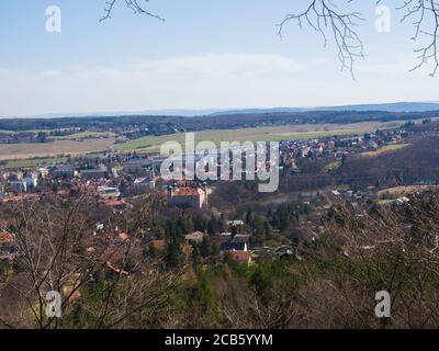 Blick auf die kleine Stadt mnisek pod brdy in tschechien mit Tres, Schloss und Gebäuden, frühem Frühling, blauer Himmel Hintergrund Stockfoto