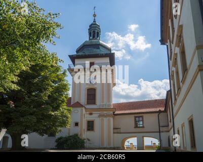 Alter Rathausturm im Schlosspark Benatky nad Jizerou mit Fußweg, Treppe, grünen Bäumen, sonnigem Sommertag, blauer Himmel Hintergrund Stockfoto