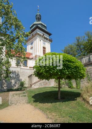 Alter Rathausturm im Schlosspark Benatky nad Jizerou mit Fußweg, Treppe, grünen Bäumen, sonnigem Sommertag, blauer Himmel Hintergrund Stockfoto