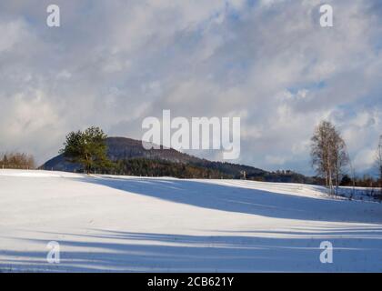 Winterfeld und Waldlandschaft schneebedeckte Landschaft mit Bäumen, Hügel und hölzernen hohen Sitz in luzicke hory Berg Stockfoto