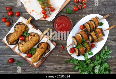 Geriebenen Fleischbällchen mit Auberginen auf Spieße. Hühnerkebab mit Gemüse und Lavasch. Diät-Fleischgericht. Stockfoto
