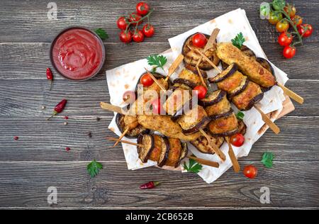 Geriebenen Fleischbällchen mit Auberginen auf Spieße. Hühnerkebab mit Gemüse und Lavasch. Diät-Fleischgericht. Die Ansicht von oben Stockfoto