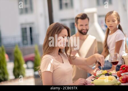 Junge nette Familie mit Abendessen und schauen zufrieden Stockfoto